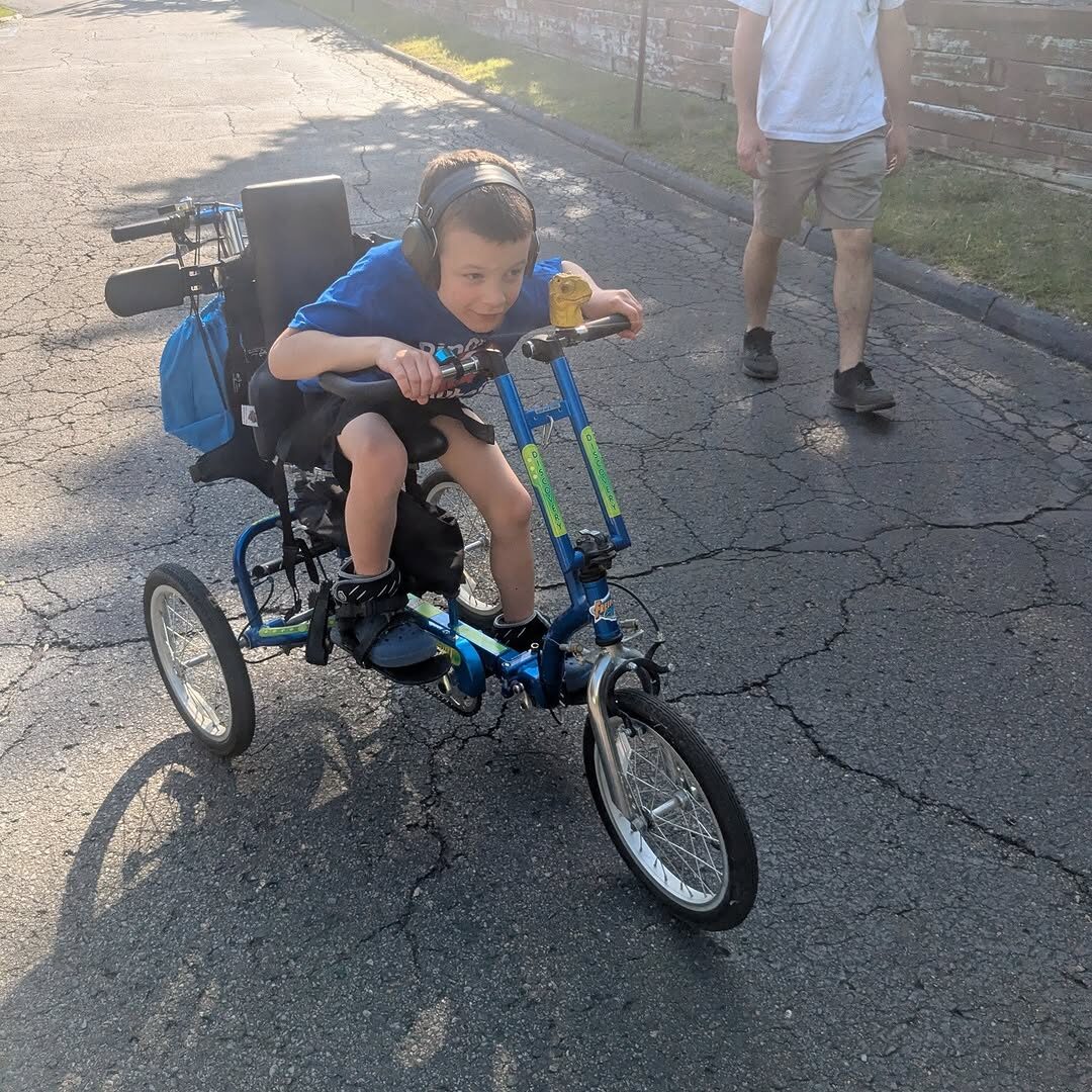 A patient riding a Freedom Concepts adaptive bike in the Clarkston clinic parking lot.